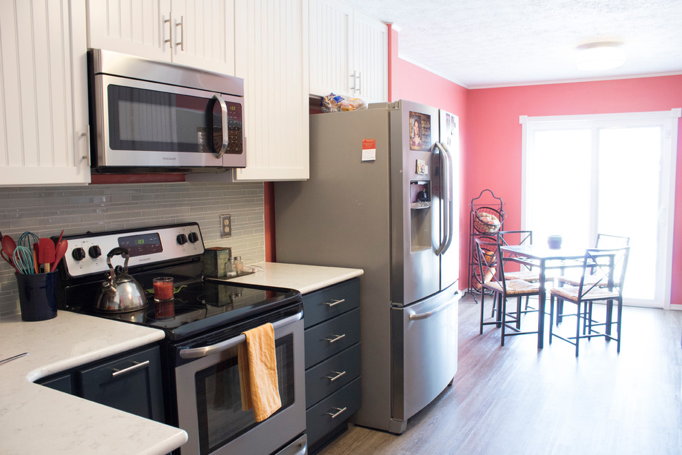 This is an example of a mid-sized beach style galley separate kitchen in Other with an undermount sink, shaker cabinets, blue cabinets, quartzite benchtops, green splashback, glass tile splashback, stainless steel appliances, vinyl floors, no island, beige floor and white benchtop.