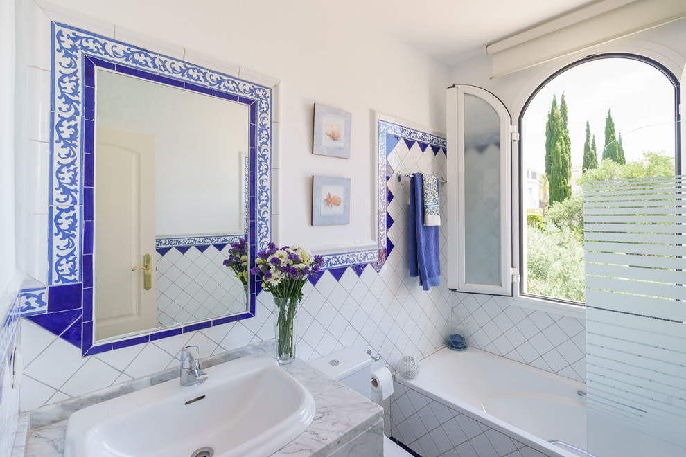 Пример оригинального дизайна: главная ванная комната среднего размера в морском стиле с ванной в нише, душем над ванной, белыми стенами и накладной раковиной
