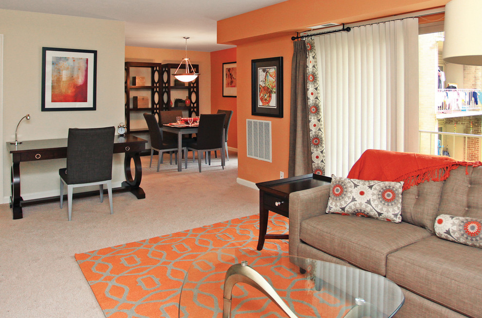 Mid-sized transitional enclosed carpeted living room photo in Other with orange walls