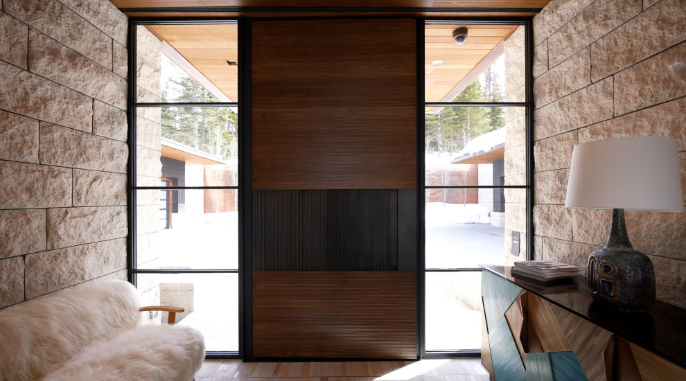 Пример оригинального дизайна: фойе среднего размера в стиле модернизм с бежевыми стенами, одностворчатой входной дверью, входной дверью из дерева среднего тона, разноцветным полом, деревянным потолком и кирпичными стенами