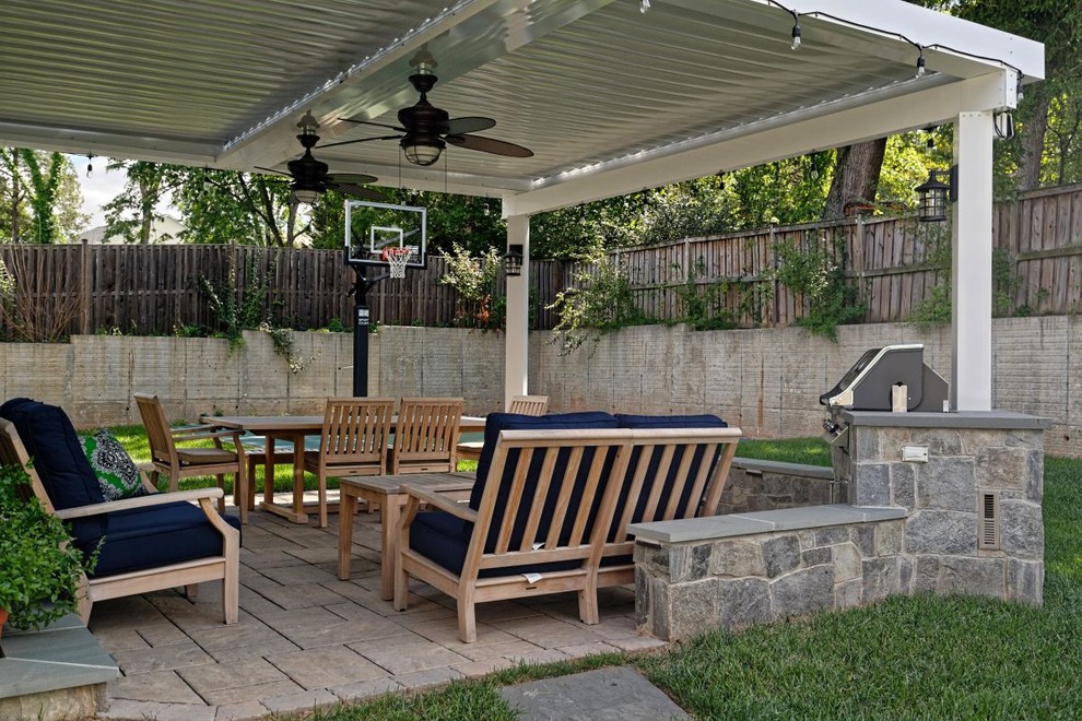 This is an example of a mid-sized arts and crafts patio in DC Metro with an outdoor kitchen, brick pavers and a pergola.