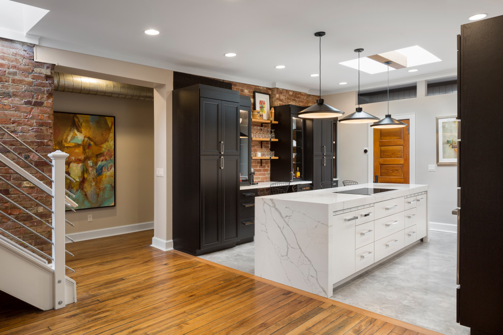 This is an example of a mid-sized modern galley eat-in kitchen in Cincinnati with flat-panel cabinets, dark wood cabinets, quartz benchtops, brown splashback, brick splashback, stainless steel appliances, medium hardwood floors, with island, grey floor and white benchtop.