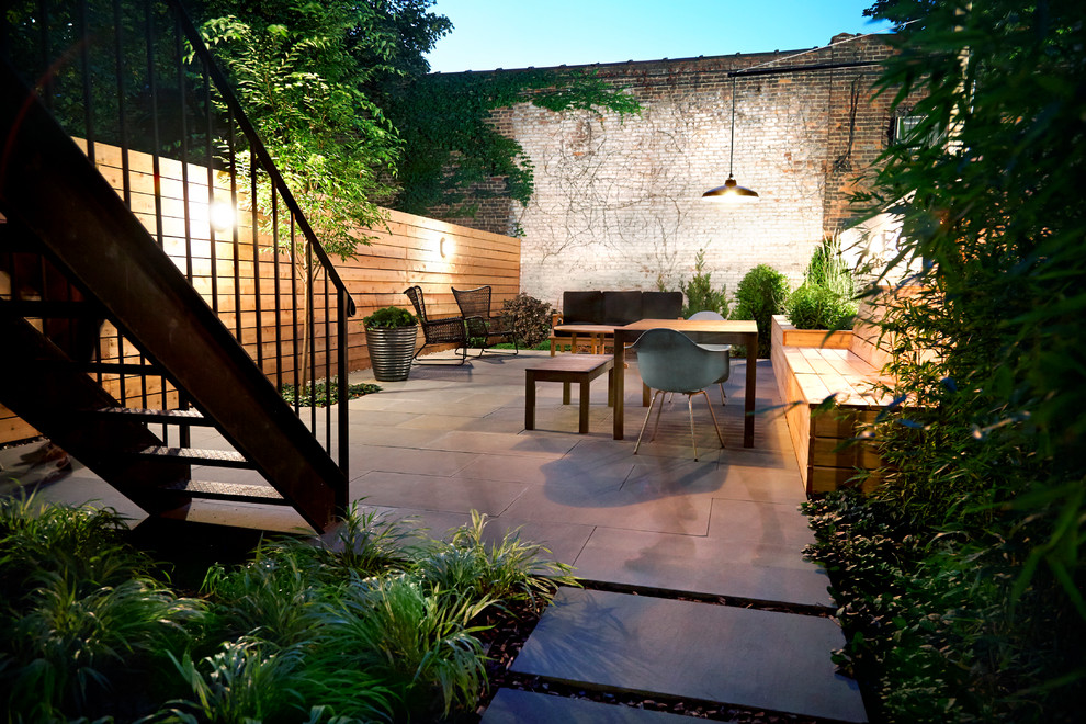 Photo of a small contemporary backyard patio in New York with no cover, a container garden and natural stone pavers.