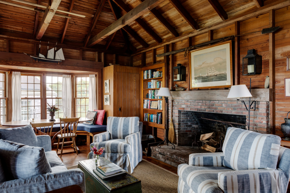 This is an example of a beach style family room in Boston with dark hardwood floors, a standard fireplace, a brick fireplace surround, no tv, exposed beam and wood walls.