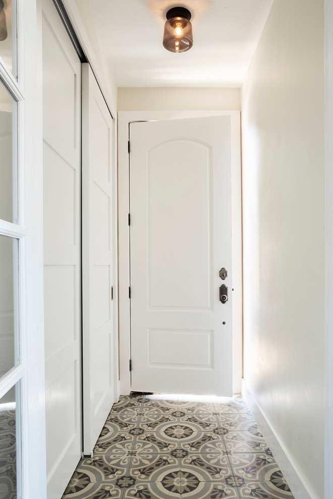 This is an example of a mid-sized contemporary entry hall in New York with beige walls, porcelain floors, a single front door and a white front door.