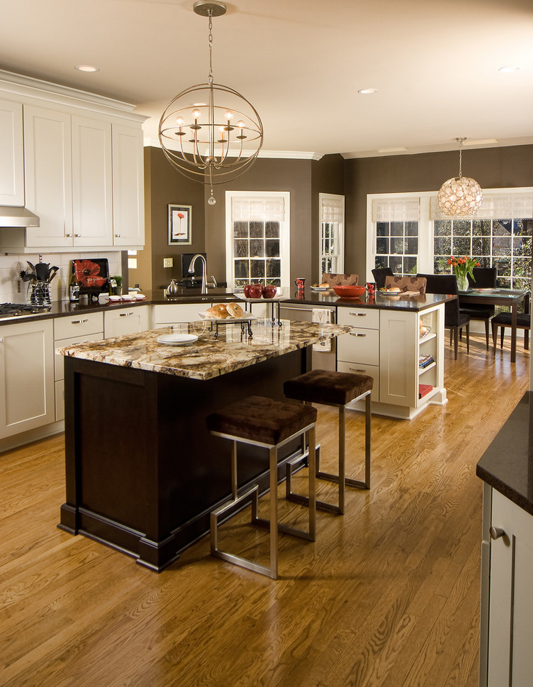 Photo of a traditional eat-in kitchen in Baltimore with shaker cabinets, white cabinets, granite benchtops, white splashback and stainless steel appliances.