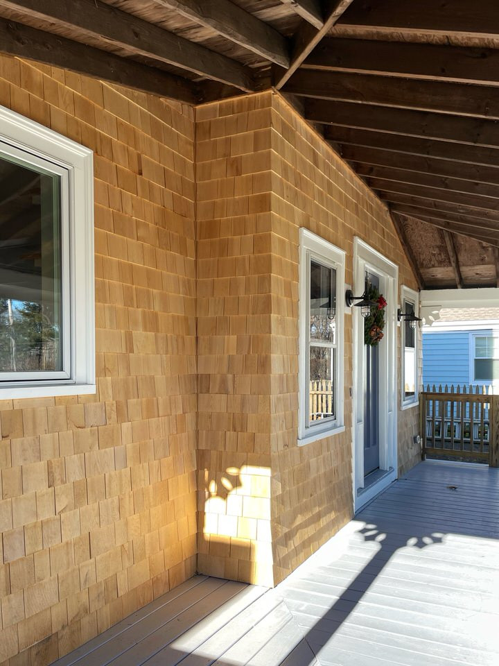 Aménagement d'une petite façade de maison grise bord de mer en bois et bardeaux à un étage avec un toit à deux pans, un toit en shingle et un toit gris.