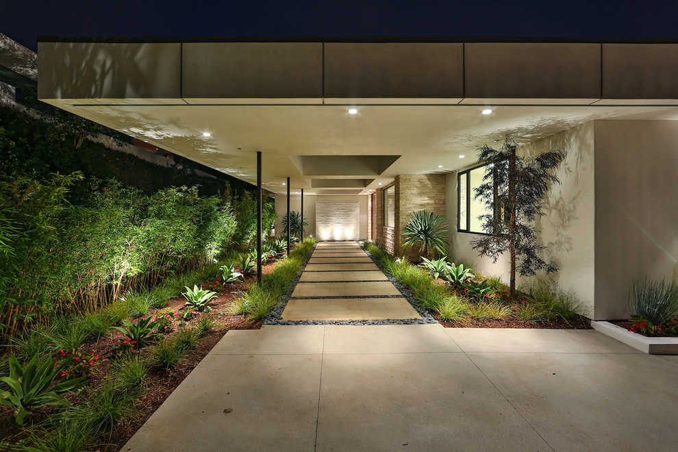 Large modern front yard shaded garden in Los Angeles with a garden path and natural stone pavers.