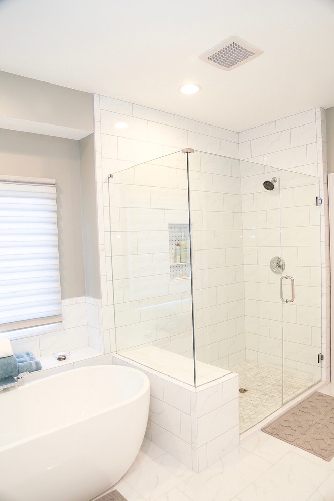 This is an example of a mid-sized transitional master bathroom in Atlanta with recessed-panel cabinets, white cabinets, grey walls, marble floors, an undermount sink, marble benchtops, white floor, a freestanding tub, a corner shower, white tile, marble and a hinged shower door.