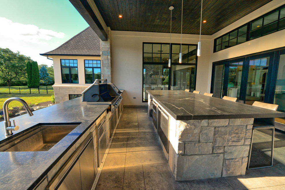 This is an example of a large galley kitchen in Indianapolis with an undermount sink, concrete benchtops, stainless steel appliances, concrete floors, black benchtop and wood.