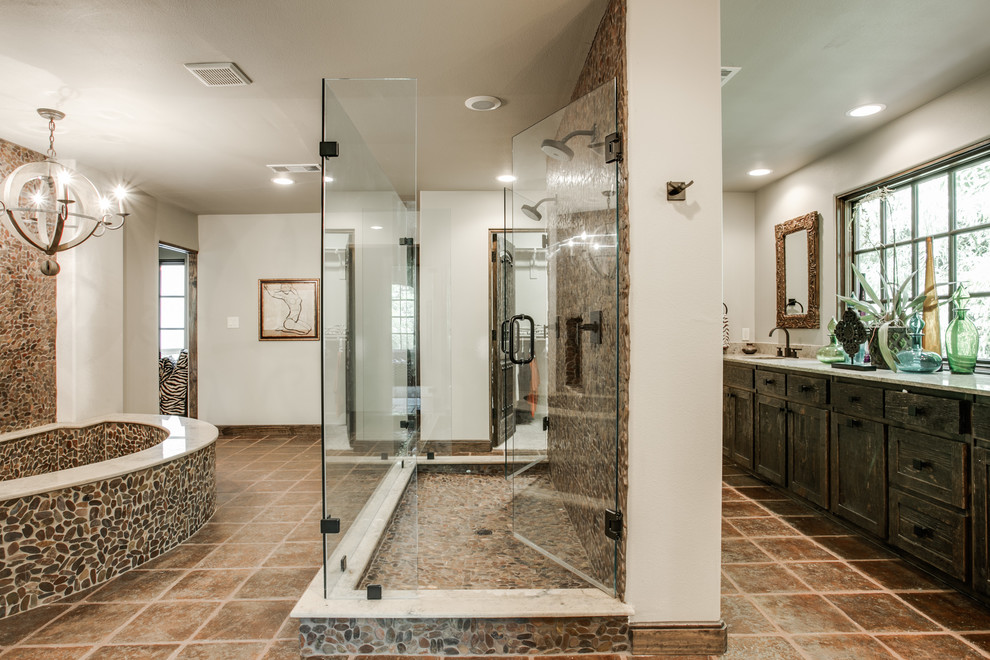 Large mediterranean master bathroom in Dallas with an undermount sink, shaker cabinets, distressed cabinets, beige tile, pebble tile, beige walls, an undermount tub, a double shower and terra-cotta floors.