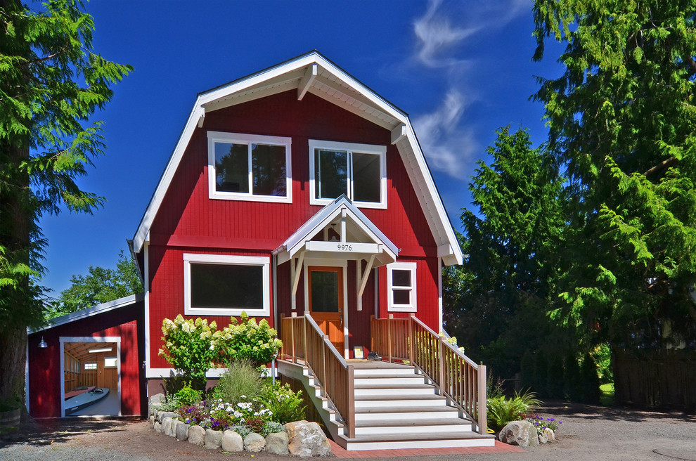 This is an example of a large country three-storey exterior in Seattle with wood siding and a gambrel roof.
