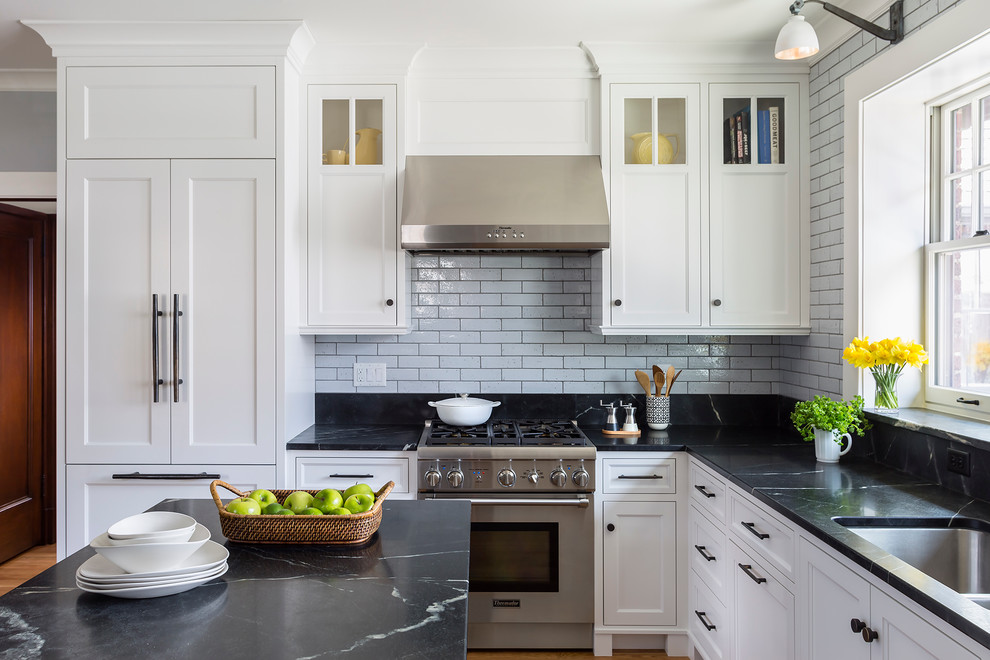 Design ideas for a transitional l-shaped kitchen in Minneapolis with an undermount sink, shaker cabinets, white cabinets, grey splashback, subway tile splashback, stainless steel appliances and with island.