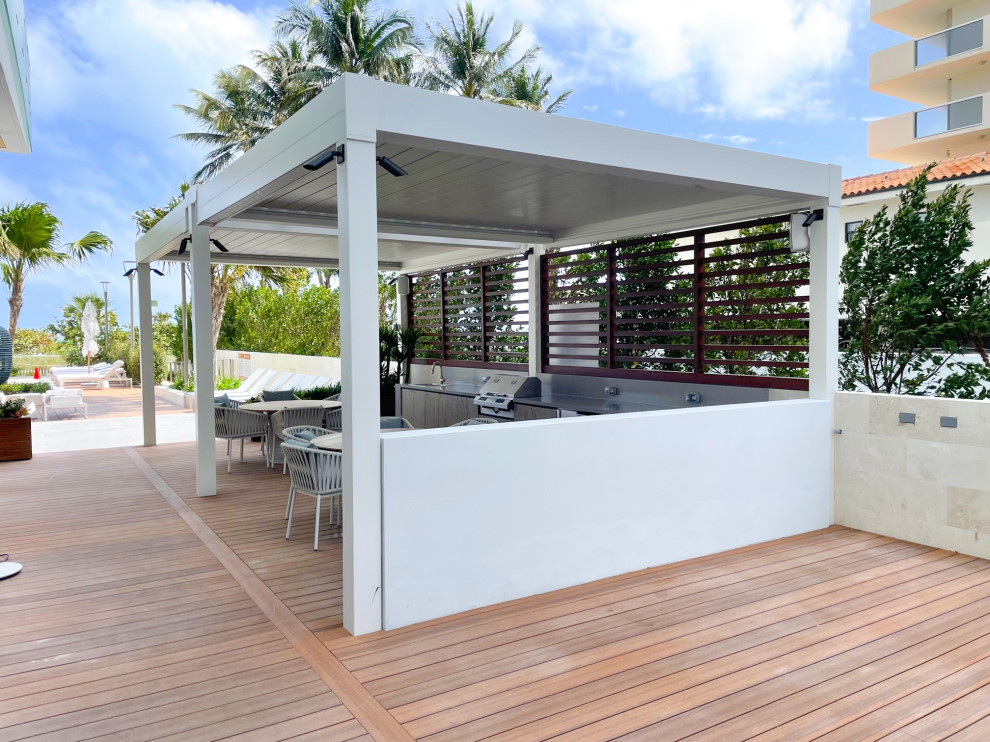 Inspiration for a large beach style courtyard and rooftop deck in Miami with an outdoor kitchen and a pergola.