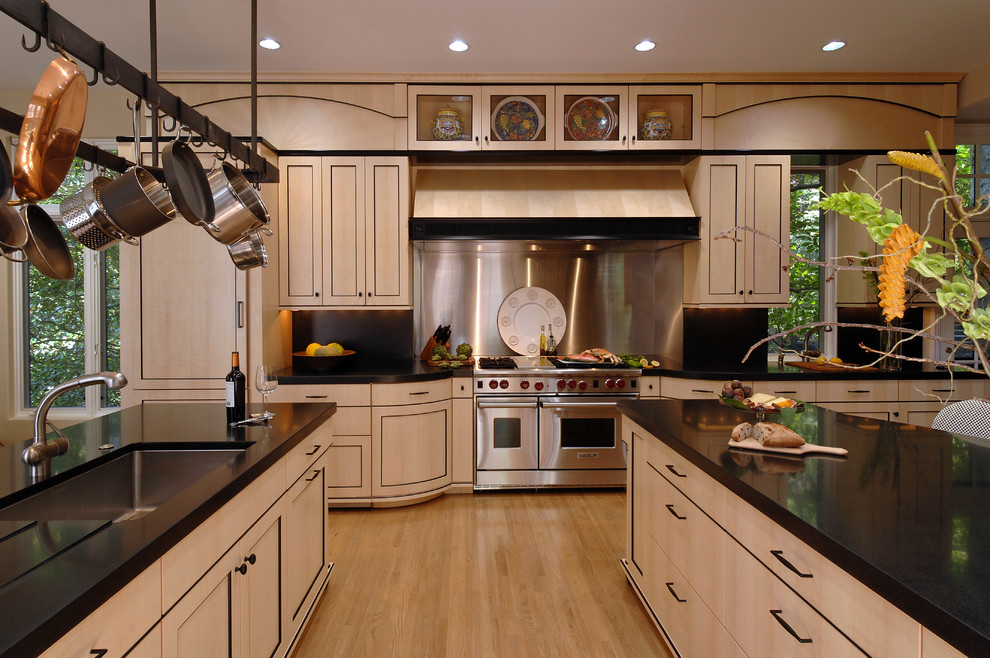 Design ideas for a large asian l-shaped eat-in kitchen in DC Metro with an undermount sink, recessed-panel cabinets, beige cabinets, solid surface benchtops, metallic splashback, metal splashback, stainless steel appliances, light hardwood floors, multiple islands and beige floor.