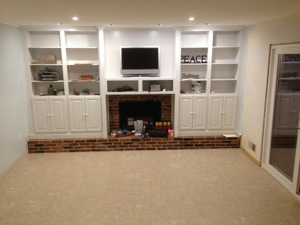 Photo of a small traditional enclosed living room in Baltimore with a library, white walls, a standard fireplace, a brick fireplace surround and a wall-mounted tv.