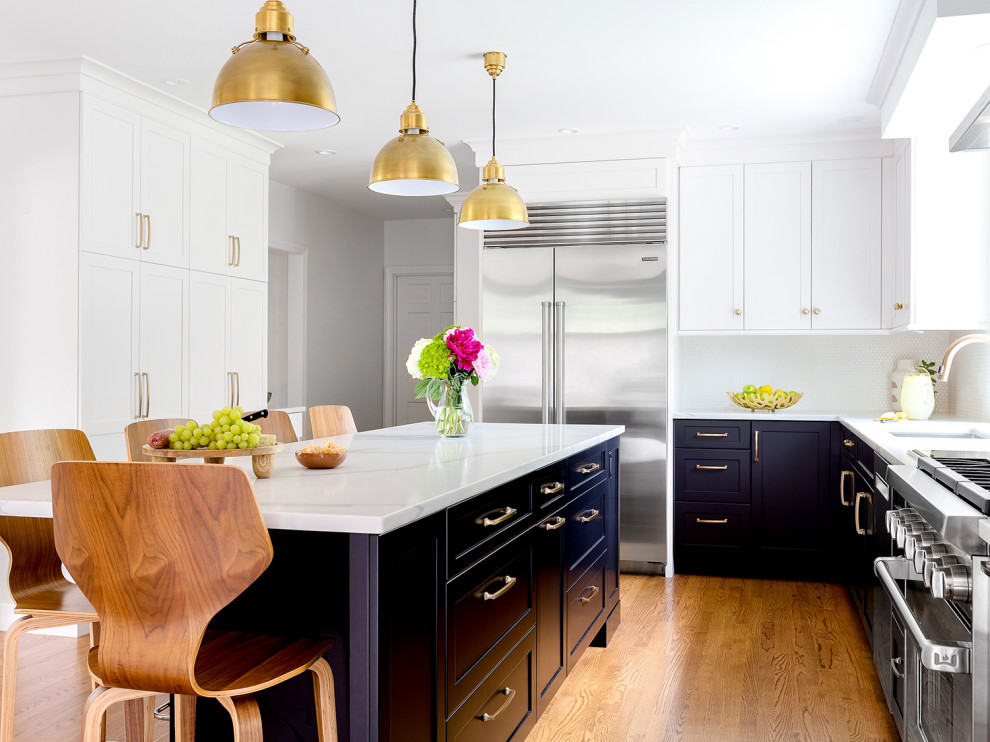 Mid-sized transitional l-shaped medium tone wood floor and brown floor kitchen photo in Boston with an undermount sink, shaker cabinets, blue cabinets, white backsplash, stainless steel appliances, an island and white countertops