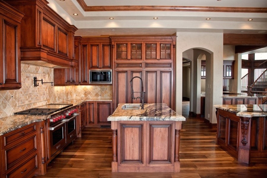 Inspiration for a large traditional separate kitchen in Denver with a double-bowl sink, louvered cabinets, medium wood cabinets, granite benchtops, beige splashback, terra-cotta splashback, panelled appliances, medium hardwood floors and with island.