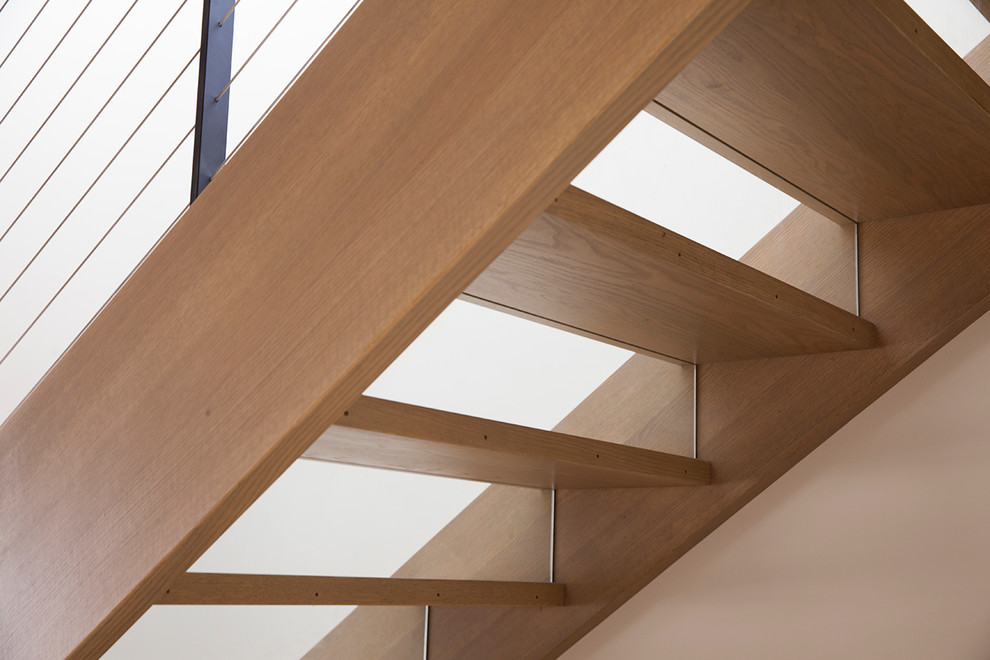 This is an example of a contemporary wood staircase in San Francisco with wood risers and metal railing.