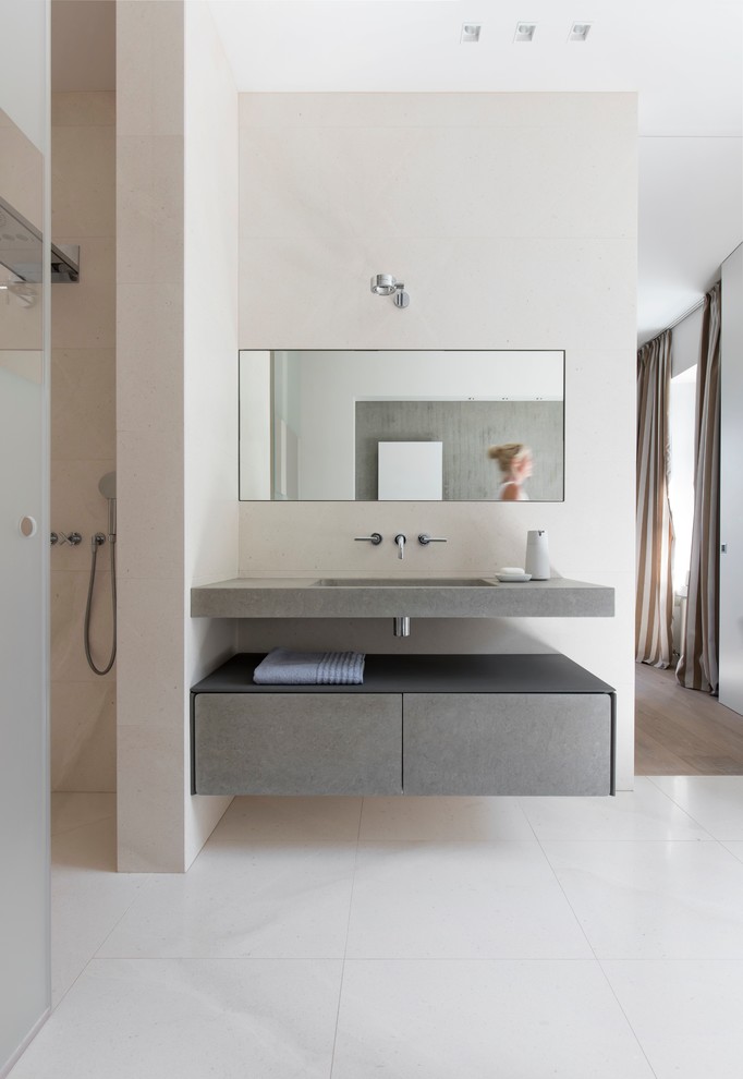 Photo of a mid-sized modern master bathroom in Other with flat-panel cabinets, grey cabinets, a freestanding tub, an alcove shower, a two-piece toilet, beige tile, limestone, white walls, limestone floors, a wall-mount sink, limestone benchtops, beige floor, a sliding shower screen and grey benchtops.