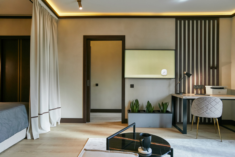 Esempio di un soggiorno eclettico di medie dimensioni con pareti beige, pavimento in laminato, TV a parete, pavimento beige e pannellatura