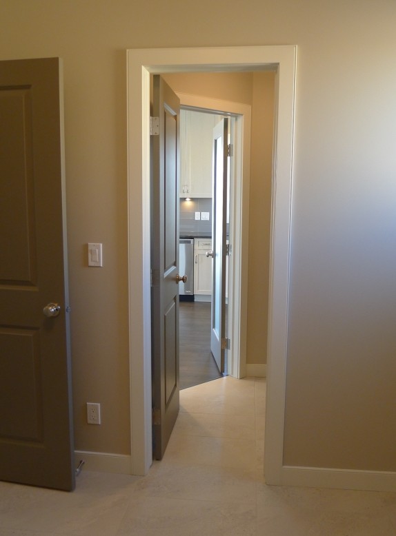 Mudroom - small transitional porcelain tile mudroom idea with beige walls and a white front door