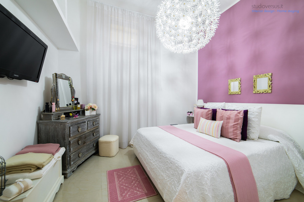 Small eclectic master bedroom in Rome with pink walls and porcelain floors.