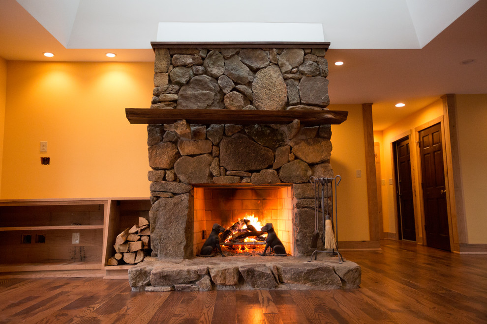 Home design - large rustic formal and open concept dark wood floor home design idea with orange walls, a standard fireplace, a stone fireplace and no tv