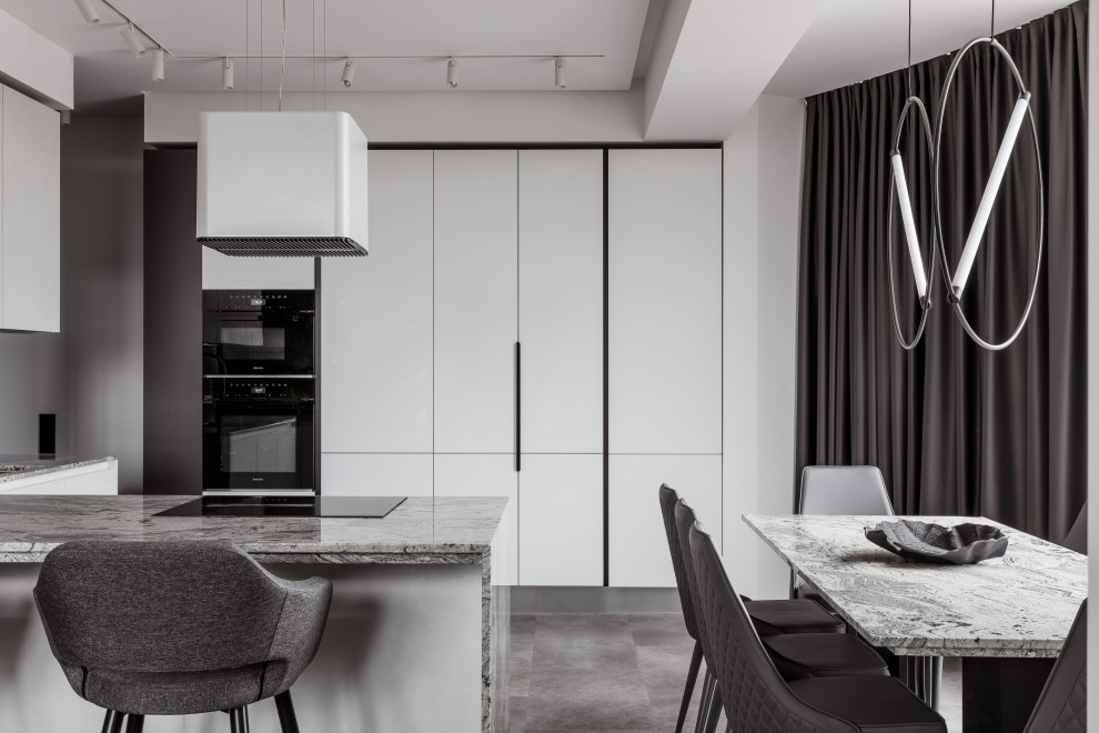 Bild på ett funkis grå grått kök, med en undermonterad diskho, släta luckor, vita skåp, granitbänkskiva, grått stänkskydd, stänkskydd i metallkakel, svarta vitvaror, vinylgolv, en köksö och grått golv