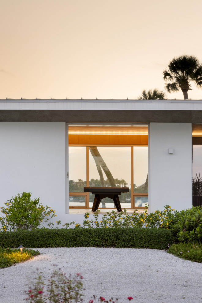 Ispirazione per la micro casa bianca contemporanea a un piano di medie dimensioni con rivestimento in stucco, copertura in metallo o lamiera e tetto grigio