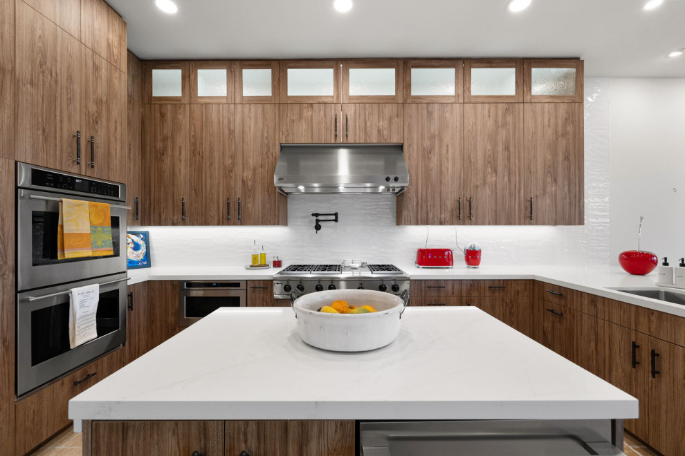 Example of a mountain style l-shaped slate floor and beige floor enclosed kitchen design with a single-bowl sink, flat-panel cabinets, medium tone wood cabinets, quartzite countertops, white backsplash, glass sheet backsplash, stainless steel appliances, a peninsula and white countertops