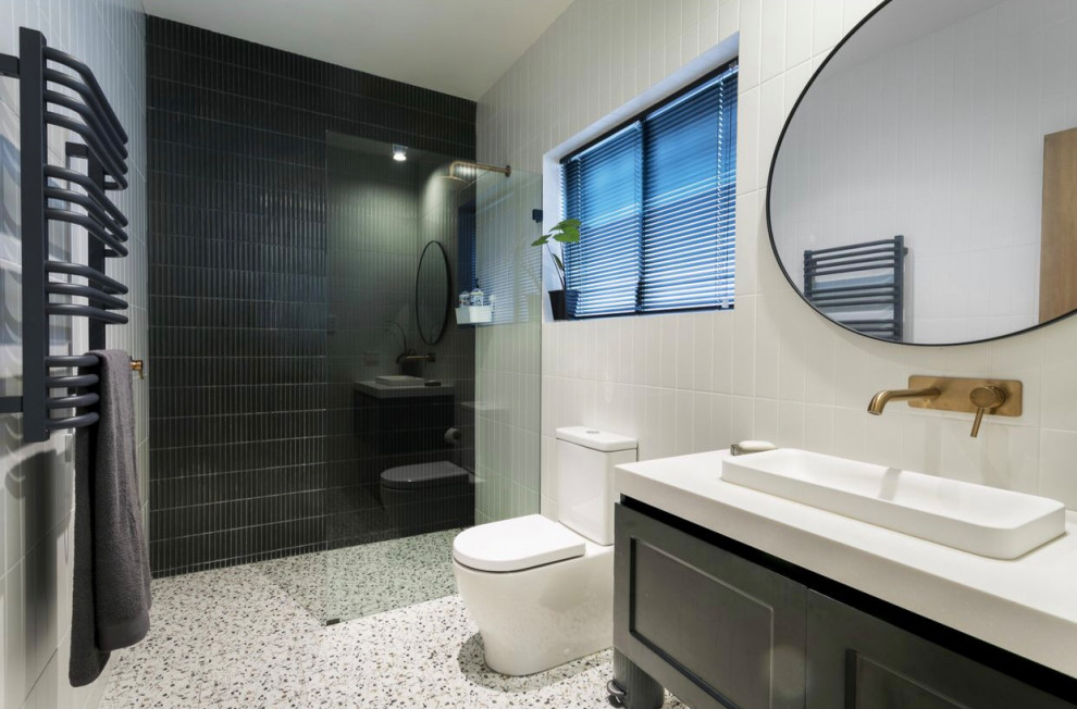 Photo of a mid-sized modern 3/4 bathroom in Sydney with shaker cabinets, grey cabinets, an open shower, a one-piece toilet, black and white tile, ceramic tile, white walls, limestone floors, engineered quartz benchtops, multi-coloured floor, white benchtops, a single vanity and a floating vanity.