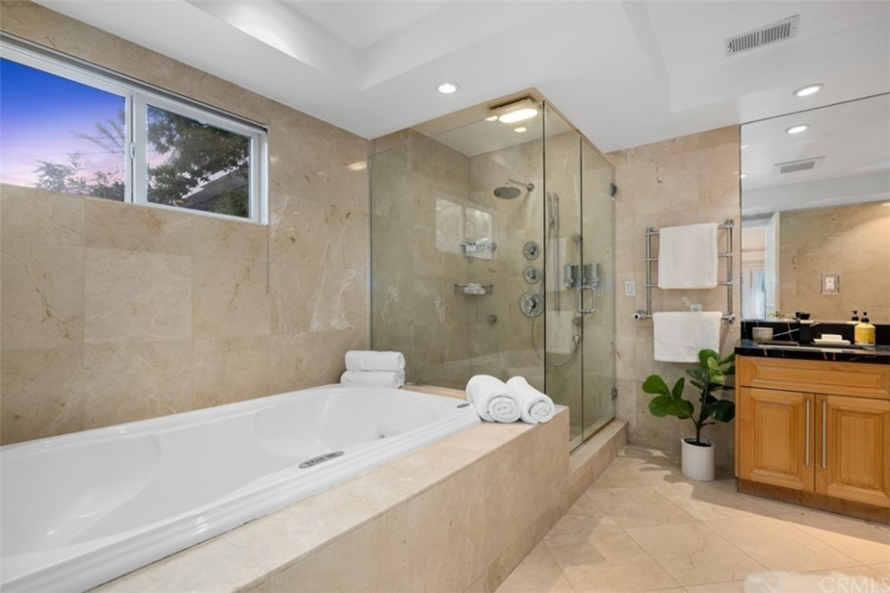 Cette image montre une très grande salle de bain principale minimaliste avec un placard à porte shaker, des portes de placard marrons, une douche d'angle, WC à poser, un carrelage beige, du carrelage en marbre, un mur beige, un sol en marbre, un lavabo posé, un plan de toilette en quartz, un sol beige, une cabine de douche à porte battante, un plan de toilette noir, une niche, meuble double vasque, meuble-lavabo suspendu, un plafond décaissé et une baignoire posée.
