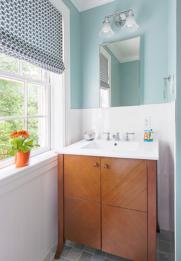 Transitional kids bathroom in DC Metro with an integrated sink, flat-panel cabinets, medium wood cabinets, gray tile, blue walls and white benchtops.