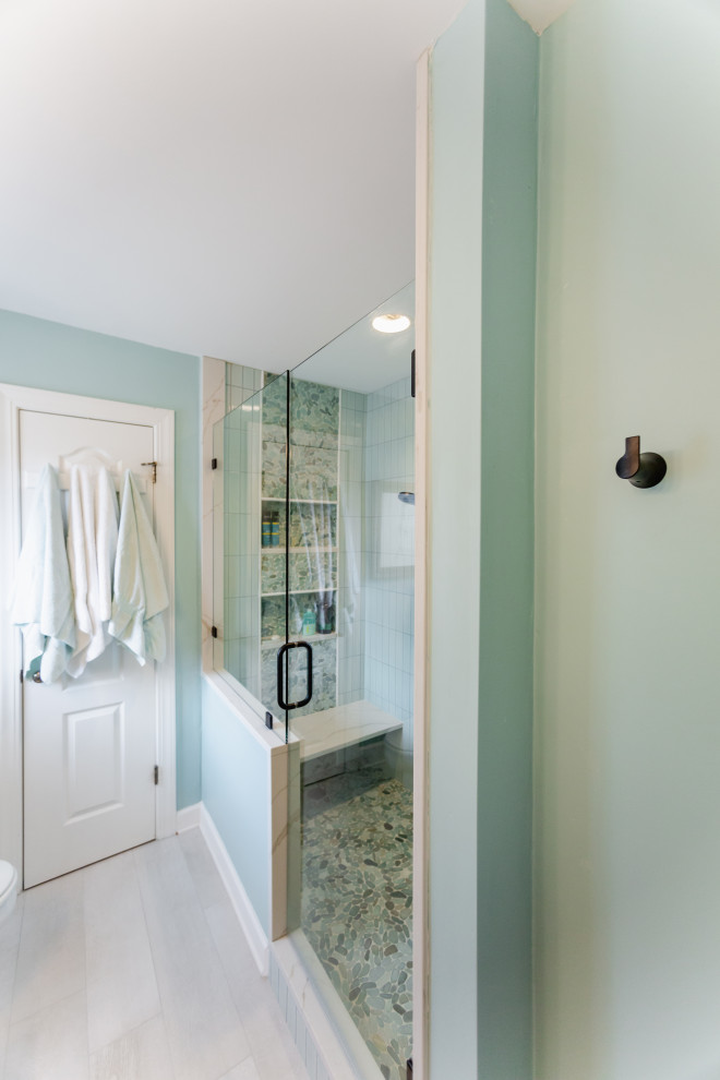 This is an example of a small beach style master bathroom in Charleston with raised-panel cabinets, light wood cabinets, an alcove shower, a two-piece toilet, green tile, porcelain tile, green walls, porcelain floors, an undermount sink, engineered quartz benchtops, beige floor, a hinged shower door, white benchtops, a shower seat, a single vanity and a built-in vanity.