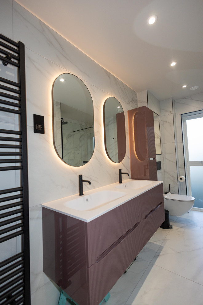 Cette image montre une petite salle de bain grise et blanche minimaliste avec un placard à porte plane, des portes de placard violettes, une baignoire posée, une douche ouverte, un carrelage blanc, du carrelage en marbre, un mur blanc, un sol en marbre, un lavabo suspendu, meuble double vasque et meuble-lavabo suspendu.