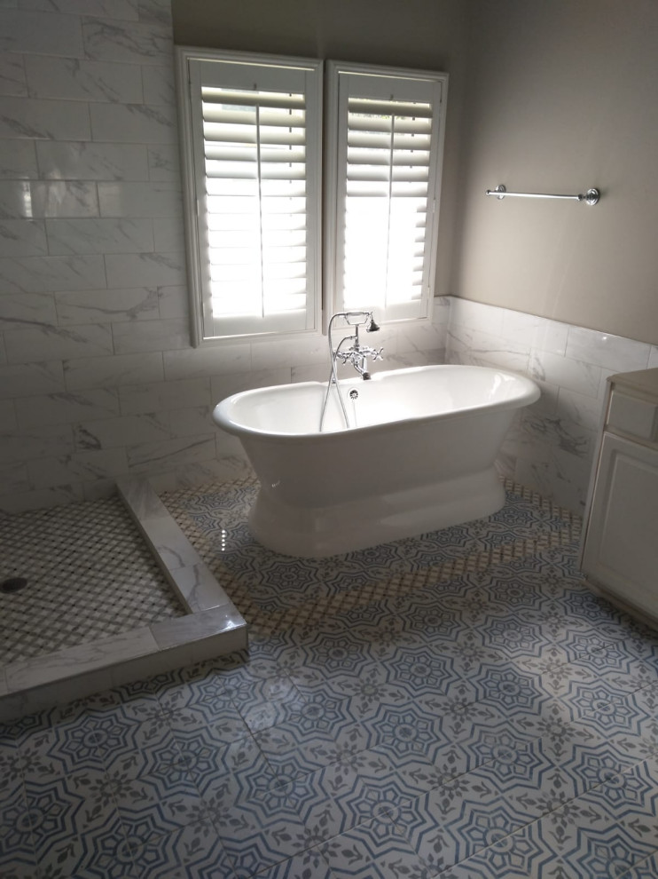На фото: главная ванная комната среднего размера с фасадами в стиле шейкер, белыми фасадами, угловым душем, унитазом-моноблоком, белой плиткой, цементной плиткой, белыми стенами, полом из керамической плитки, консольной раковиной, мраморной столешницей, серым полом, открытым душем, белой столешницей, тумбой под одну раковину, встроенной тумбой и кессонным потолком