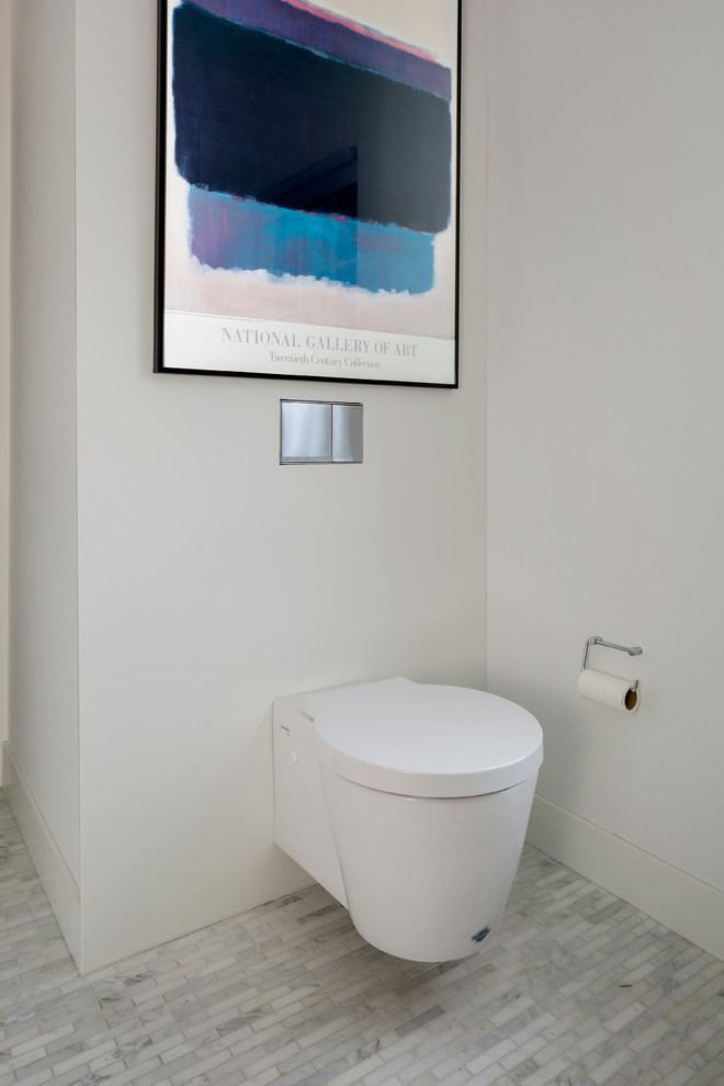 Inspiration for a small contemporary powder room in Kansas City with flat-panel cabinets, dark wood cabinets, a wall-mount toilet, white tile, pebble tile, white walls, mosaic tile floors, an integrated sink and solid surface benchtops.