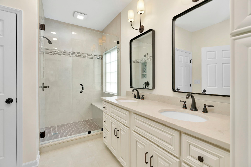 This is an example of a mid-sized modern master bathroom in Charlotte with raised-panel cabinets, white cabinets, an open shower, white tile, porcelain tile, white walls, porcelain floors, engineered quartz benchtops, beige floor, beige benchtops, an enclosed toilet, a double vanity and a built-in vanity.