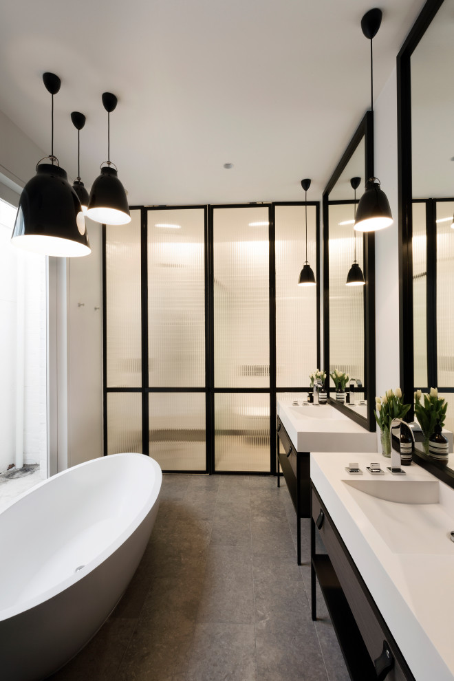 Inspiration for a mid-sized contemporary master bathroom in Melbourne with a freestanding tub, a one-piece toilet, white tile, porcelain tile, porcelain floors, an integrated sink, soapstone benchtops, white benchtops, an enclosed toilet, a double vanity and a freestanding vanity.