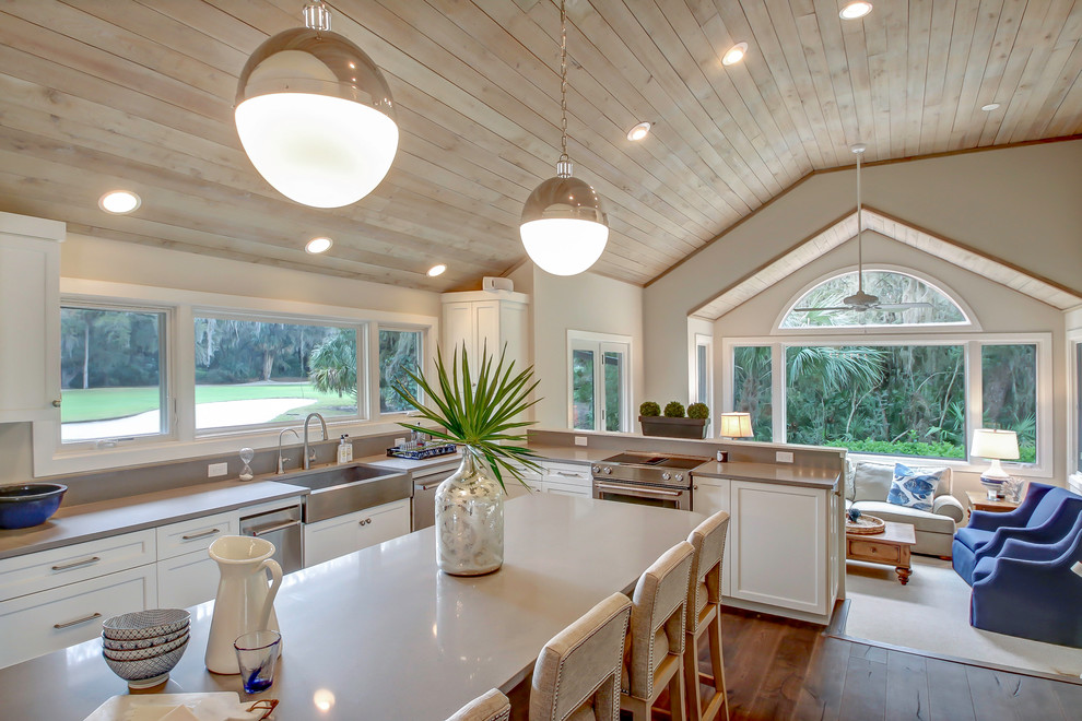 Eat-in kitchen - large transitional l-shaped medium tone wood floor eat-in kitchen idea in Jacksonville with a farmhouse sink, shaker cabinets, white cabinets, quartz countertops, gray backsplash, stone slab backsplash, stainless steel appliances and an island