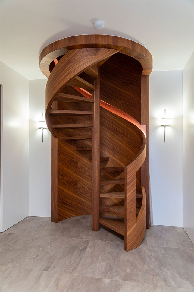 Aménagement d'un escalier hélicoïdal rétro avec des marches en verre, des contremarches en bois et un garde-corps en bois.