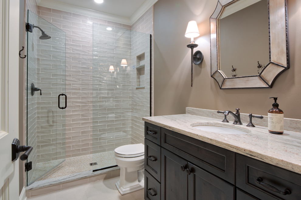 This is an example of a mid-sized traditional bathroom in Minneapolis with flat-panel cabinets, beige tile, pink walls, porcelain floors, an integrated sink, granite benchtops, white floor, dark wood cabinets and a hinged shower door.