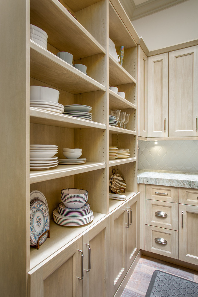 Mid-sized arts and crafts u-shaped kitchen pantry in Dallas with a farmhouse sink, recessed-panel cabinets, light wood cabinets, quartzite benchtops, white splashback, ceramic splashback, panelled appliances, medium hardwood floors, with island, brown floor and beige benchtop.