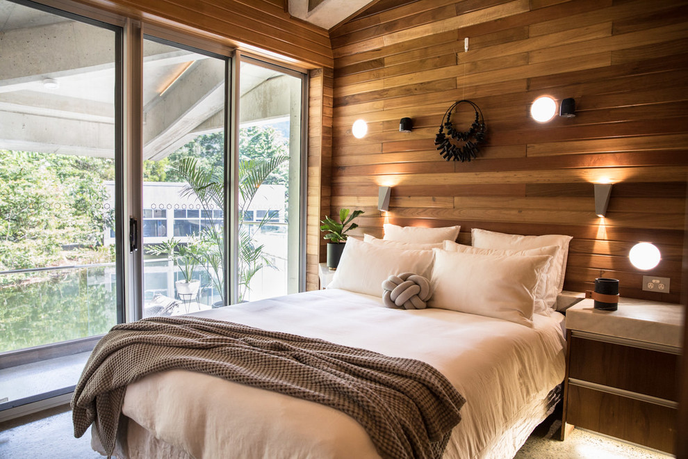 This is an example of a beach style bedroom in Cairns with brown walls and no fireplace.