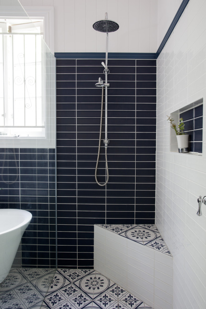 На фото: главная ванная комната среднего размера в классическом стиле с открытым душем, синей плиткой, керамической плиткой, синими стенами, полом из цементной плитки, синим полом, сиденьем для душа и панелями на части стены