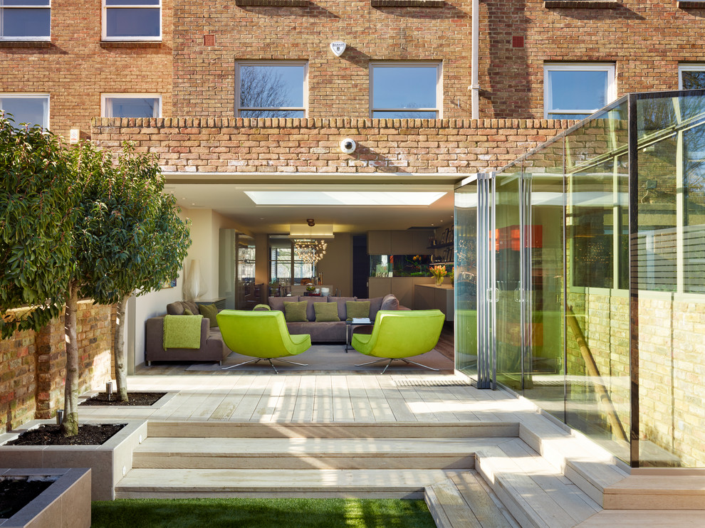 Inspiration for a transitional backyard patio in London with decking and no cover.