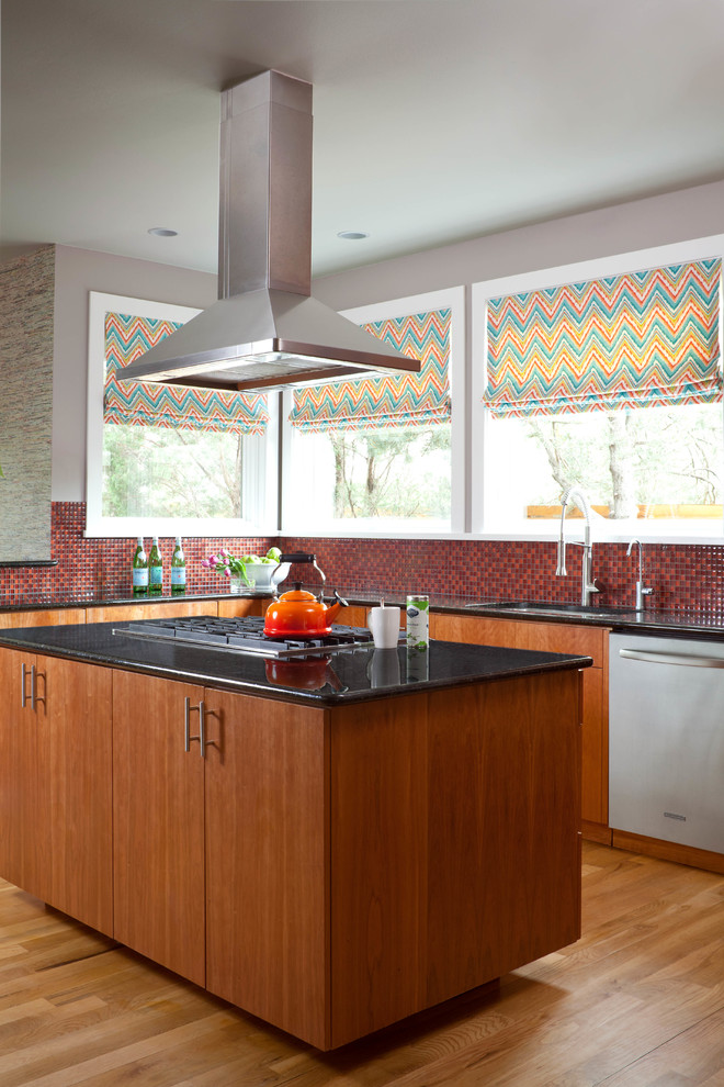 Kitchen - mid-sized u-shaped medium tone wood floor kitchen idea in Denver with an undermount sink, flat-panel cabinets, medium tone wood cabinets, granite countertops, red backsplash, glass tile backsplash, stainless steel appliances and an island