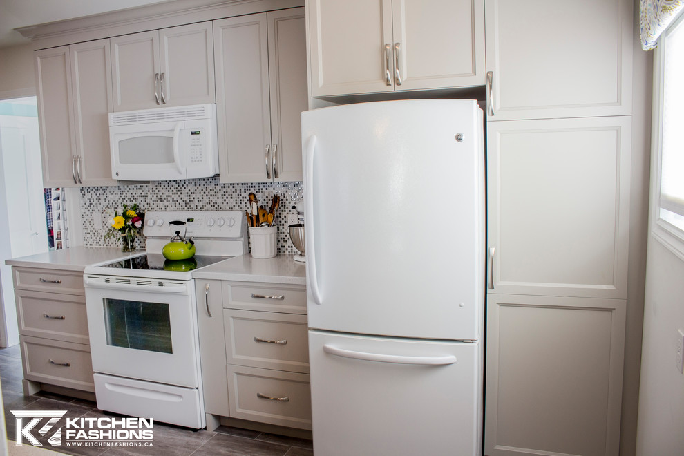 Inspiration for a mid-sized transitional single-wall ceramic tile open concept kitchen remodel with an undermount sink, shaker cabinets, gray cabinets, solid surface countertops, gray backsplash, mosaic tile backsplash, white appliances and an island