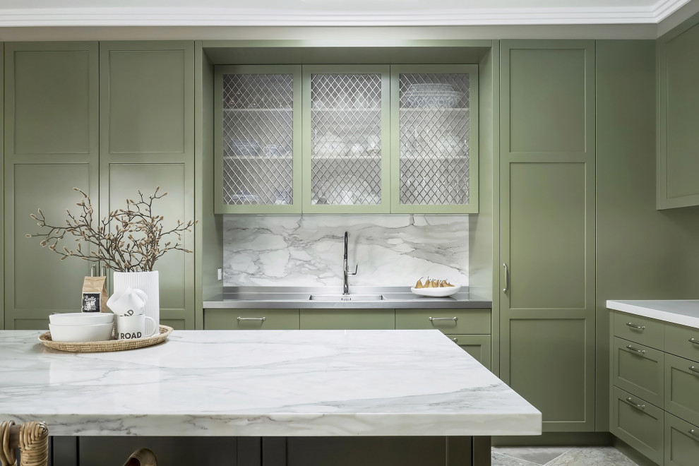 Foto på ett mellanstort vintage grå kök, med gröna skåp, en undermonterad diskho, skåp i shakerstil, marmorbänkskiva, grått stänkskydd, stänkskydd i marmor, rostfria vitvaror, kalkstensgolv, en köksö och grått golv
